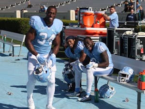 Running backs Elijah Hood (34), TJ Logan (8) and tailback Khris Francis (1) share a laugh on the sideline during the North Carolina football team's Spring Game on Saturday.
