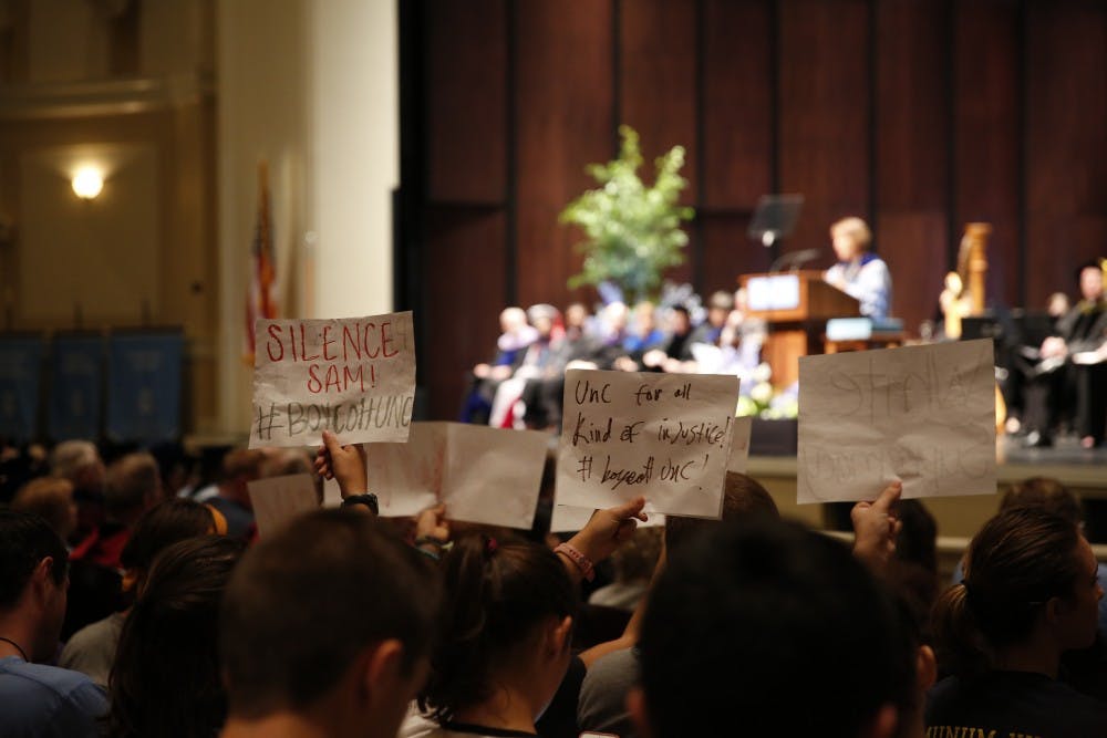 <p>Students silently protest for Silent Sam's removal during the 2017 University Day Speech in Memorial Hall.</p>