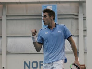 UNC's Benjamin Sigouin pumps his fist in celebration against Texas Christian on Feb. 5 in the Cone-Kenfield Tennis Center.
