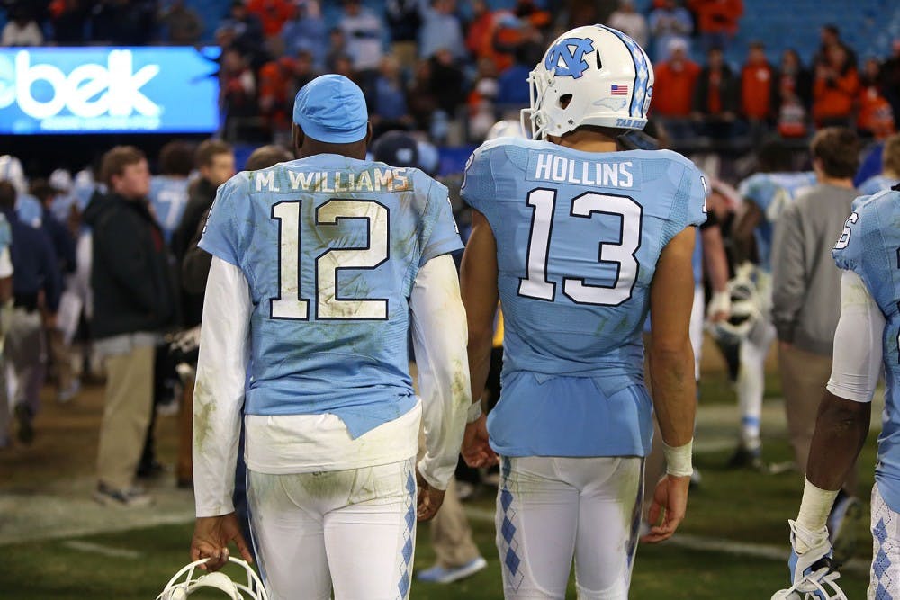 Marquise Williams (12) and Mack Hollins (13) walk back to the Carolina locker room at the conclusion of the game.&nbsp;