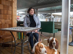 Eleanor Lacy sits outside of her new Chapel Hill restaurant, Bombolo, with her two basset hounds, Claude and Boniface on Wednesday, March 9, 2022. Lacy co-owns Bombolo with her brother, Garrett Fleming, in which they will serve casual Italian food.