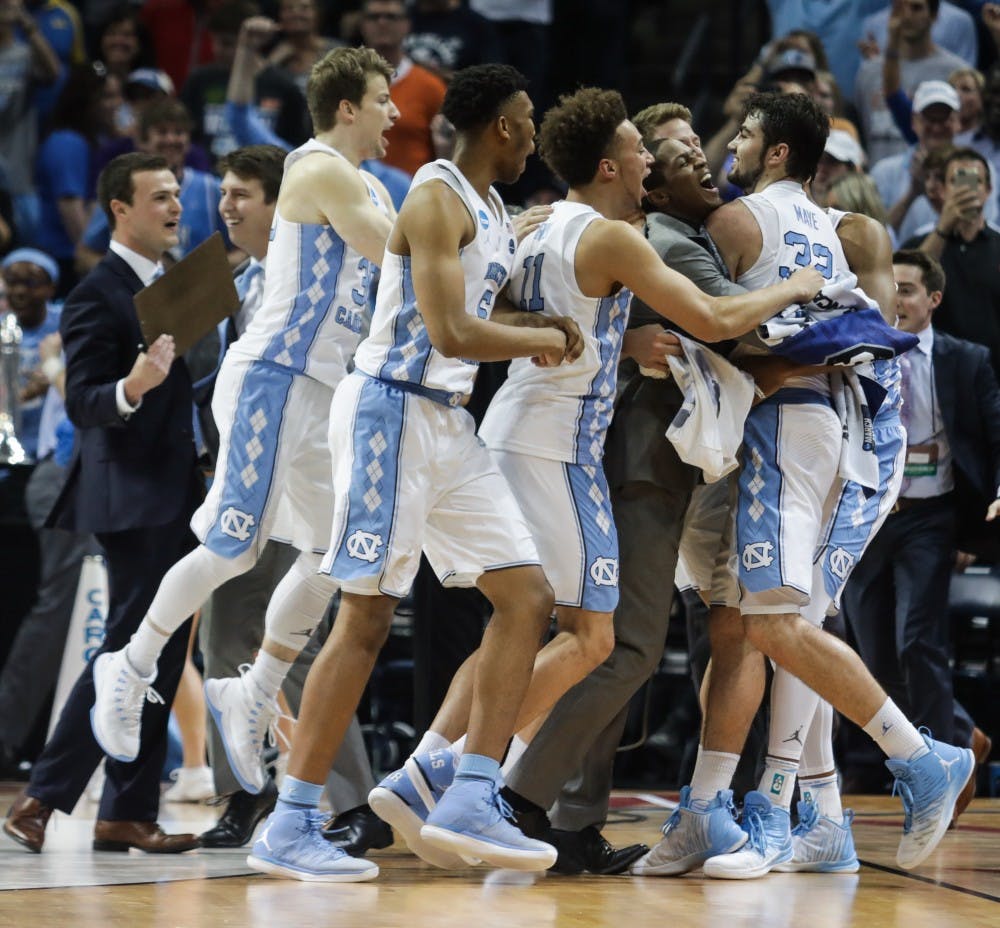 The UNC basketball team swarms Luke Maye (32) after winning  the NCAA Elite Eight game against Kentucky in Memphis on Sunday.
