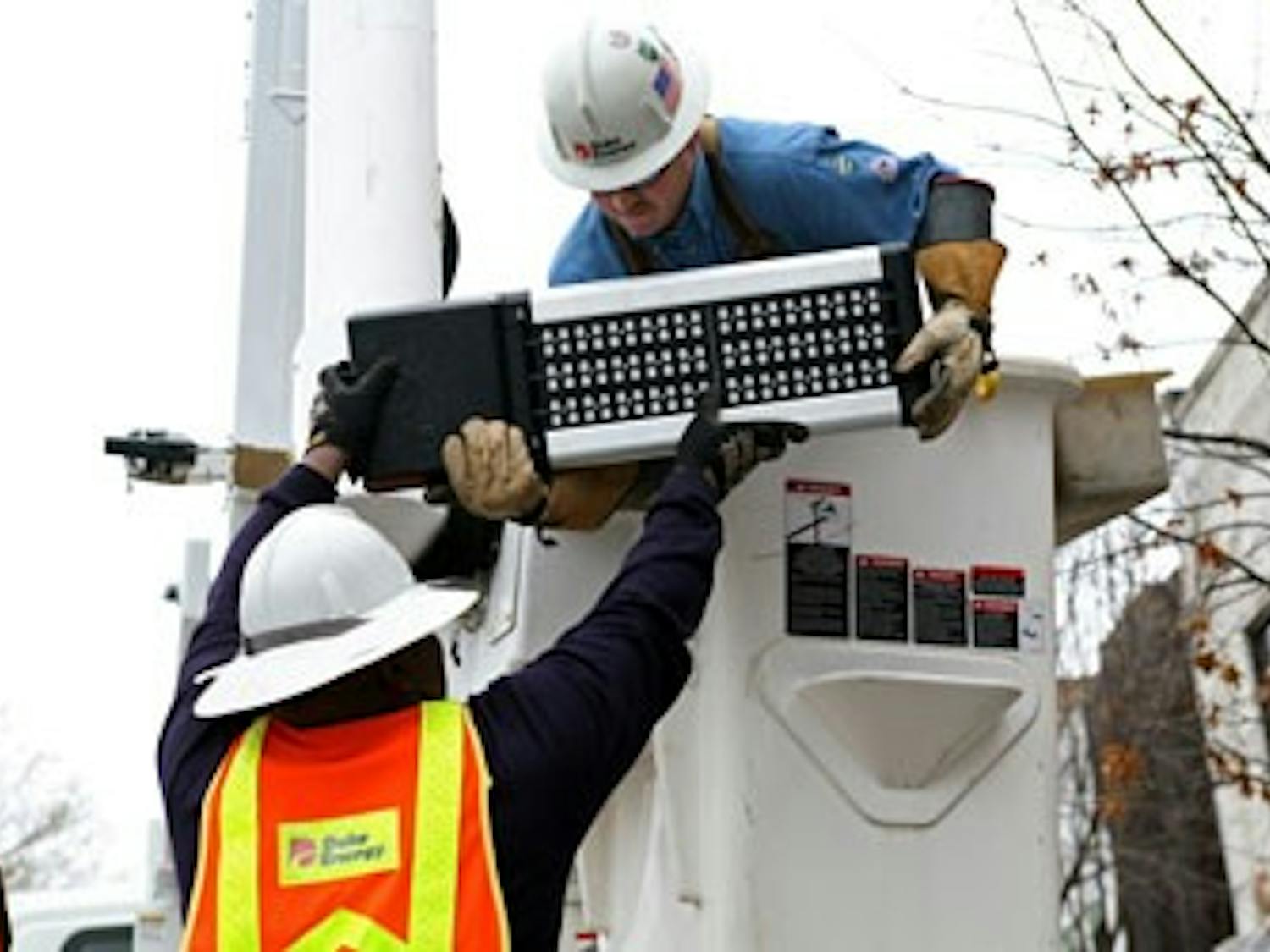 Duke Energy workers install one of 10 LED streetlights on Franklin Street in 2012 as part of a 12-month pilot program to evaluate the effectiveness of the LED lamps in increasing safety at night. The lamps are also expected to last longer and lower carbon emissions.