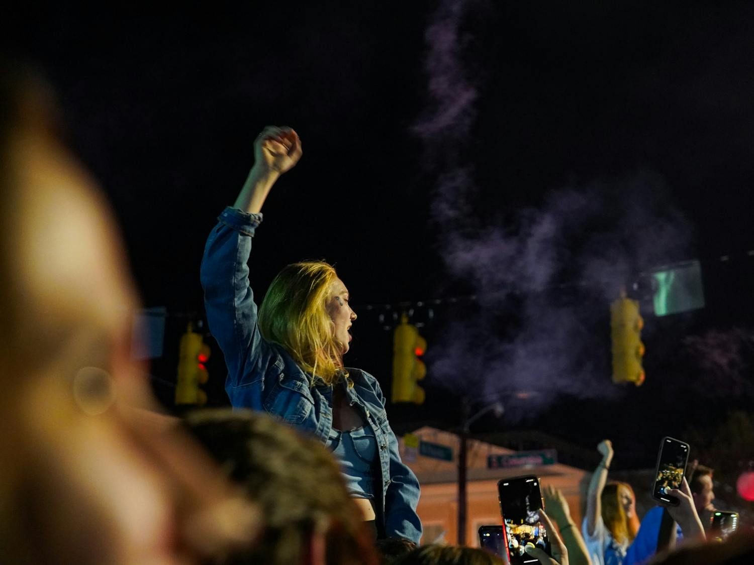 A UNC Chapel Hill fan is lifted onto someone's shoulders at the intersection of E. Franklin St and Columbia St and celebrates the team's triumph over Duke in the 2022 Final Four matchup on April 3, 2022. UNC beat Duke 81-77. Photo courtesy of Morgan Pirozzi.