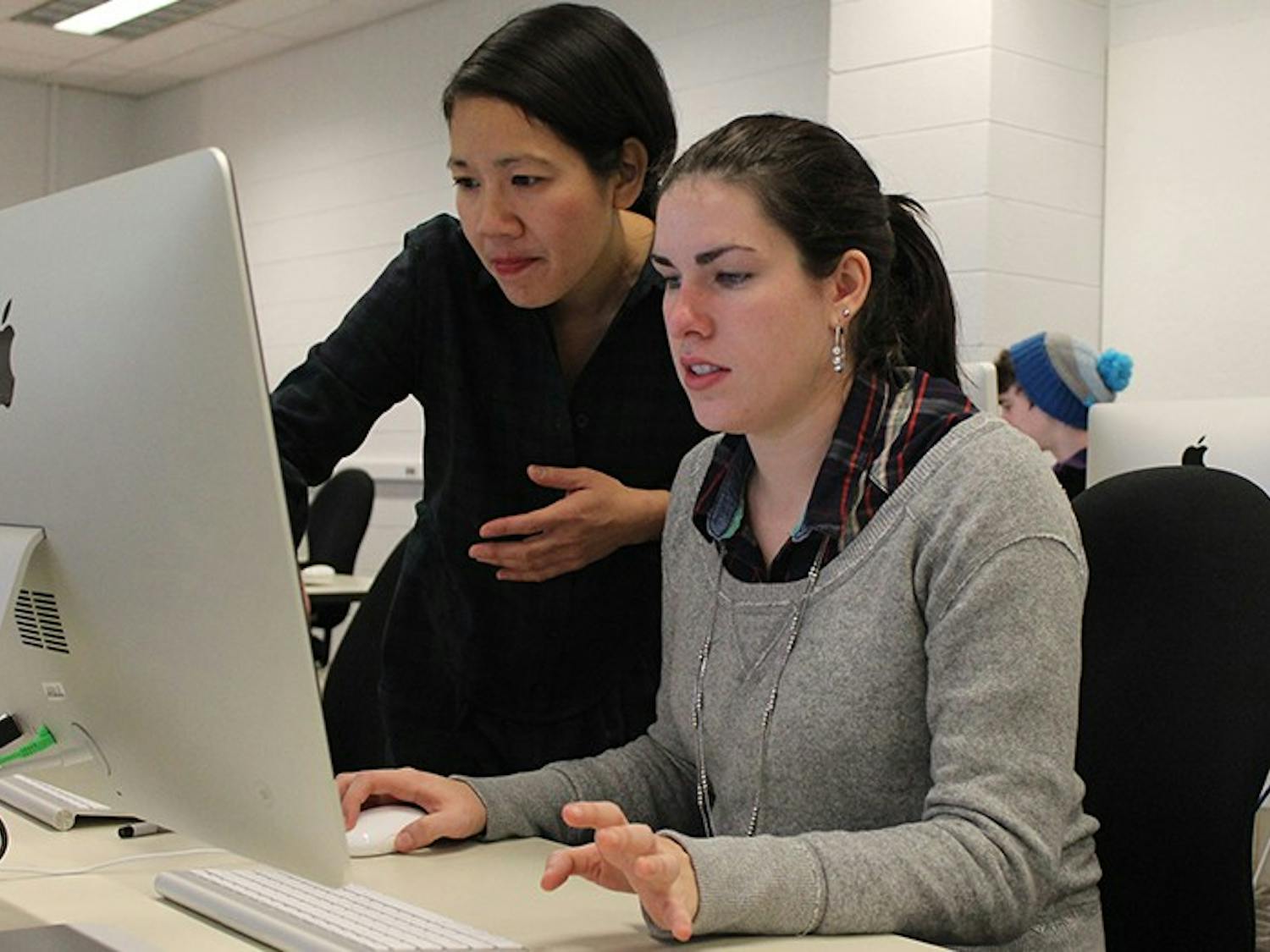 Professor Hong-an Truong talks to Audrey Anderson, a sophomore drama and communications major, as she works on her final project in Art 106, "Core Concepts: Time." The project is a way to show time-based works of art through digital media.