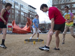 (From left) First-years Russell Engle, Max Sherrill, Nick Belk and Bennett Stillerman play Spikeball in front of a sculpture outside of Granville Towers on Tuesday, Feb. 5, 2019. The steel installation, titled "Going Through" and designed by Robert Winkler, stands as one of several public art displays in the Town of Chapel Hill.
