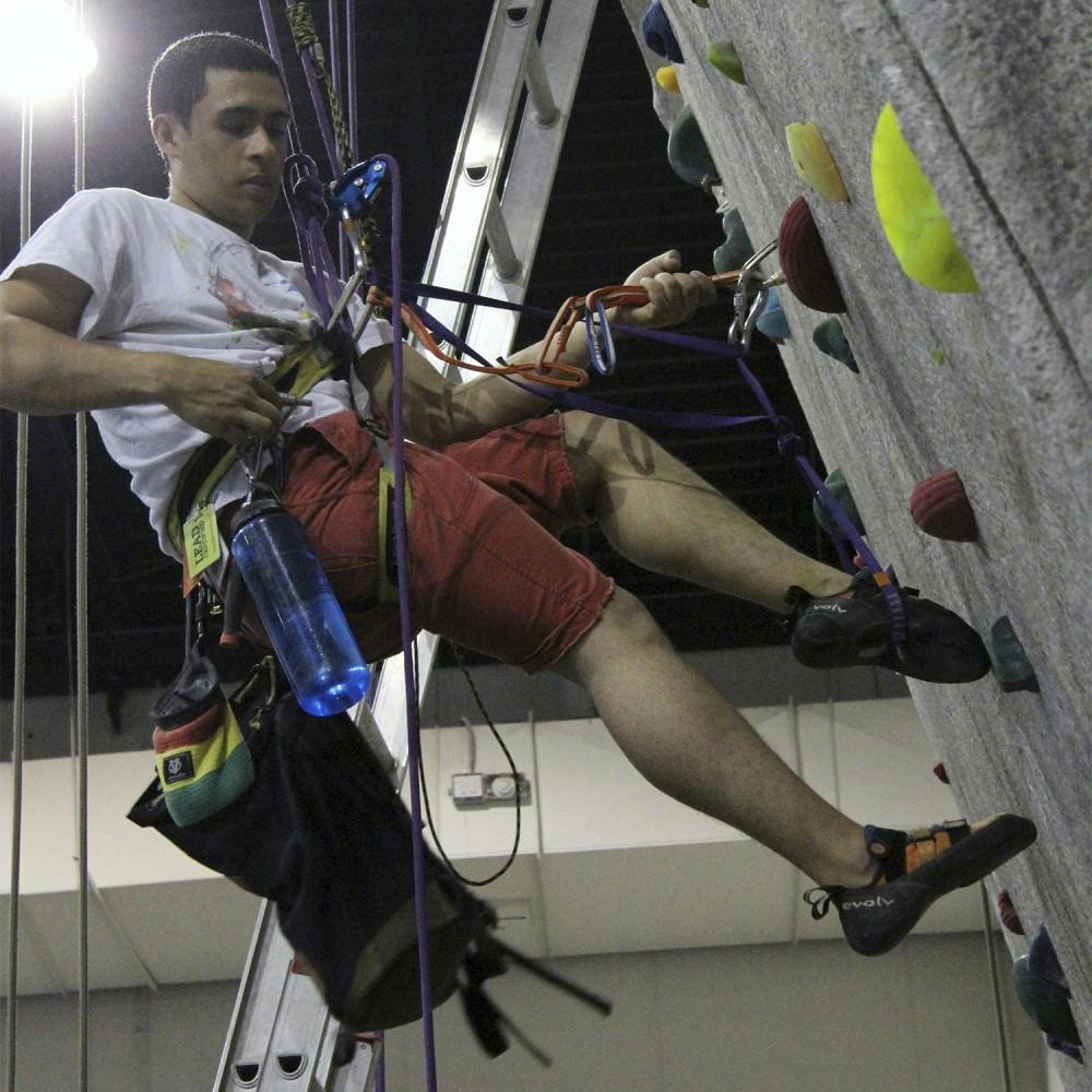 Christian Reyes climbs a rock wall on campus. Campus Recreation has now provided students with the option to auto belay when climbing so that barriers for new climbers are removed.