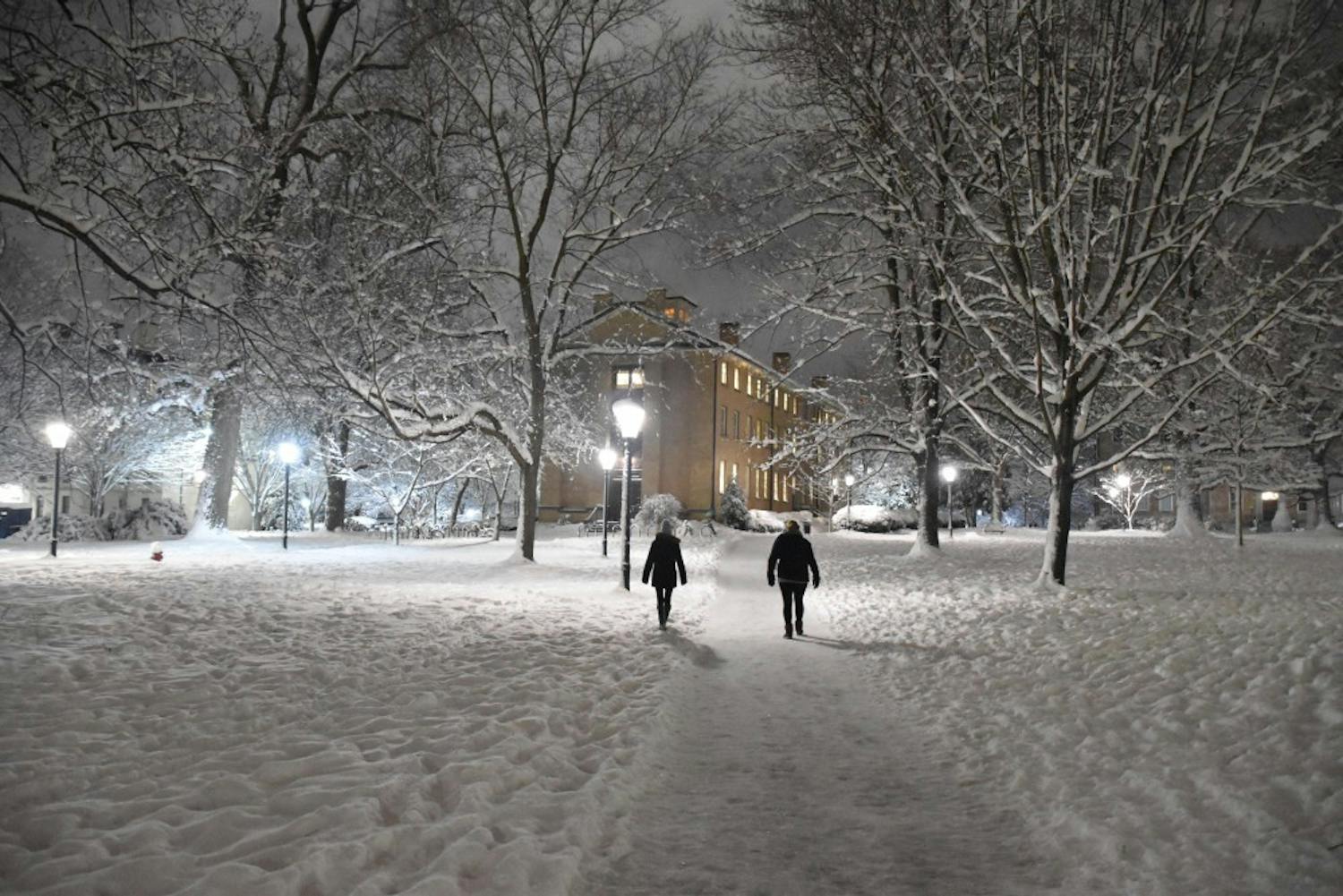 People walk through snowy North Campus on a Wednesday night in 2018.