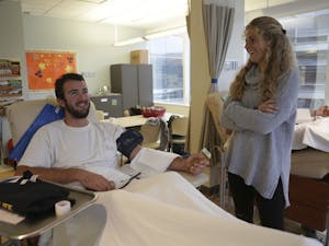 Tommy Bancroft (left), a long snapper on UNC-CH's football team, donates platelets and talks with Emma Bozek (right), a midfielder and forward on the field hockey team. Bozek is one of five students who organized the event.