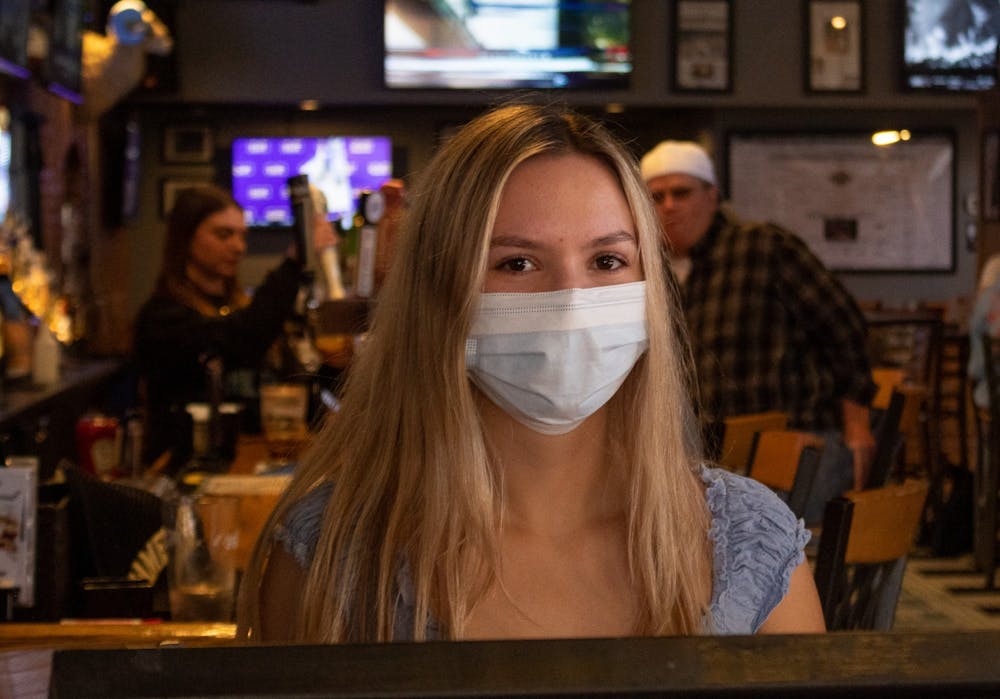 UNC junior Sophie Lorenzo, a hostess at Four Corners, wears a mask during her shift on Sunday, Mar. 6, 2022, the day before Orange County lifted its mask mandate.