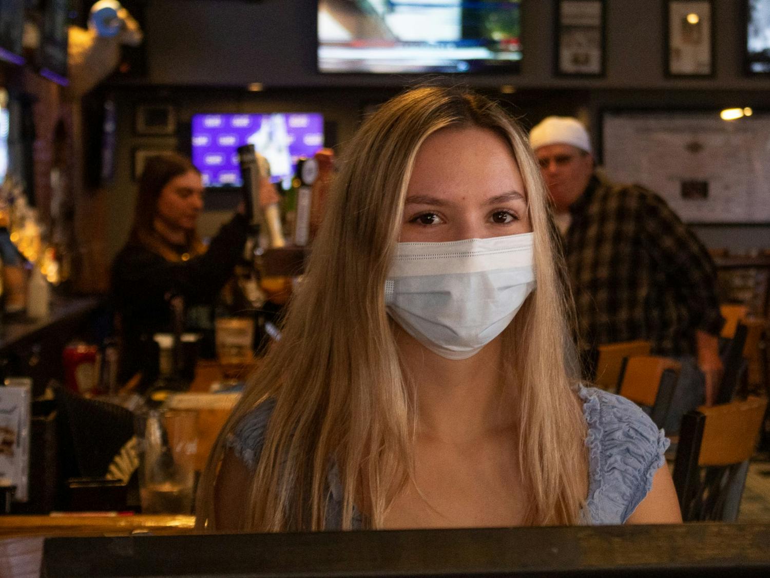 UNC junior Sophie Lorenzo, a hostess at Four Corners, wears a mask during her shift on Sunday, Mar. 6, 2022, the day before Orange County lifted its mask mandate.