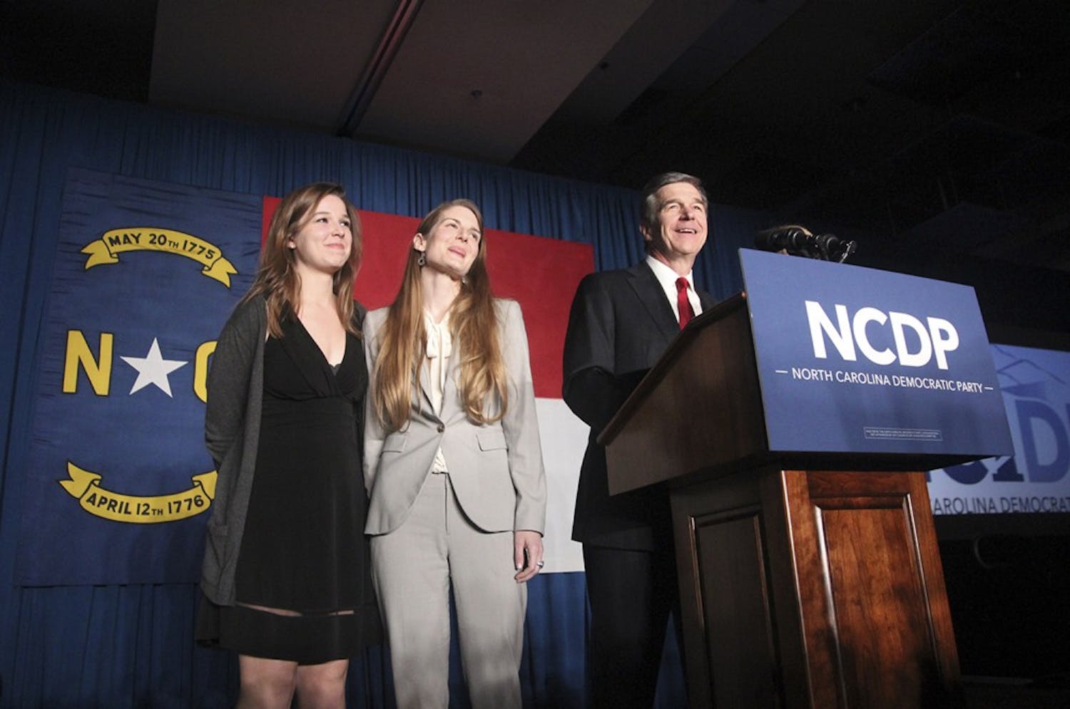 North Carolina Governor-elect Roy Cooper stands with two of his daughters at the North Carolina Democratic Party on election night on November 8th.&nbsp;