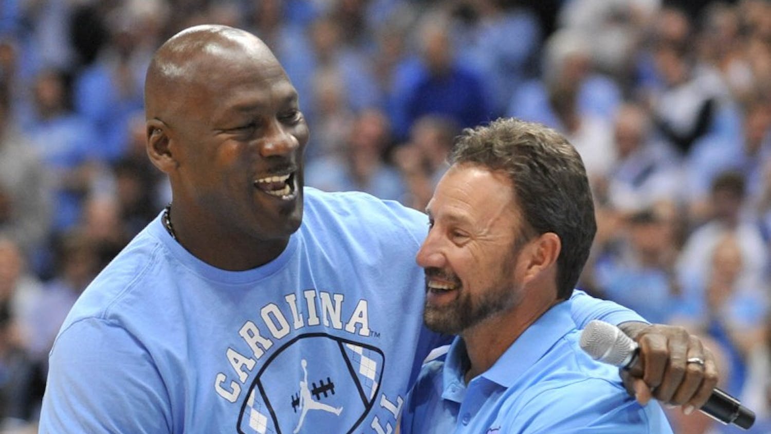 Former North Carolina basketball player and NBA Hall of Fame inductee Michael Jordan shakes hand with North Carolina football coach Larry Fedora at halftime of Saturday night's game. Jordan made an appearance to announce a new partnership between the Jordan brand and the North&nbsp;Carolina football team starting in the 2017 season.