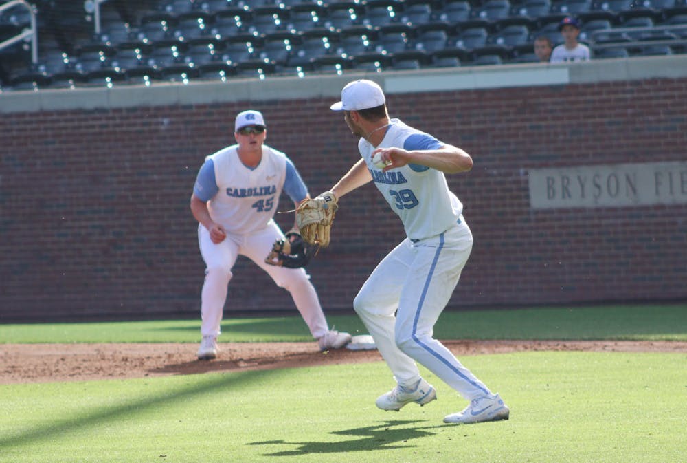Junior pitcher Brandon Schaeffer (39) throws the ball to first baseman Hunter Stokely (1) to get a Wake Forest runner out. UNC won 12-3 versus Wake Forest at home on Saturday, May 14, 2022, in the second game of the three game series.