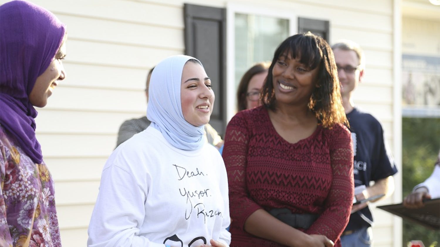 Sana Ansari (left), (from Cary, N.C., who recently graduated from UNC), represented "OurThreeWinners.org" and Doha Hindi (right of Ansari), a junior at NC State, spoke in honor of Deah, Yusor and Razan at the Habitat for Humanity's dedication ceremony on Tuesday. 

Habitat for Humanity dedicated Petrina McCoy's home to Deah Barakat, Yusor Abu-Salha, and Razan Abu-Salah, the three Muslim students who were killed in February. 