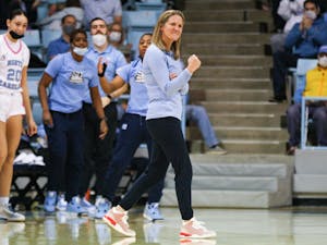 UNC women's head basketball coach Courtney Banghart celebrates at the beginning of a timeout at a game against Miami on Sunday, Feb. 6, 2022, in Carmichael Arena.