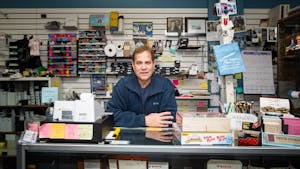 Alan Cohen, owner of Crazy Alan's Emporium, leans on the checkout counter of his store in Chapel Hill, N.C., on Wednesday, March 15, 2023. Crazy Alan's Emporium is an office supplies store that has been in business for over 20 years.