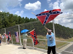 Demonstrators wave confederate flags over the American Tobacco Trail I-40 Pedestrian Bridge in Durham on Sunday, July 7. 