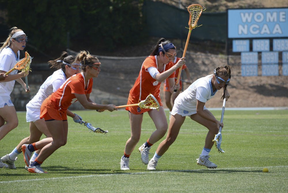 Midfielder Catie Woodruff (34) chases after the ball while being chased by Syracuse defenders.