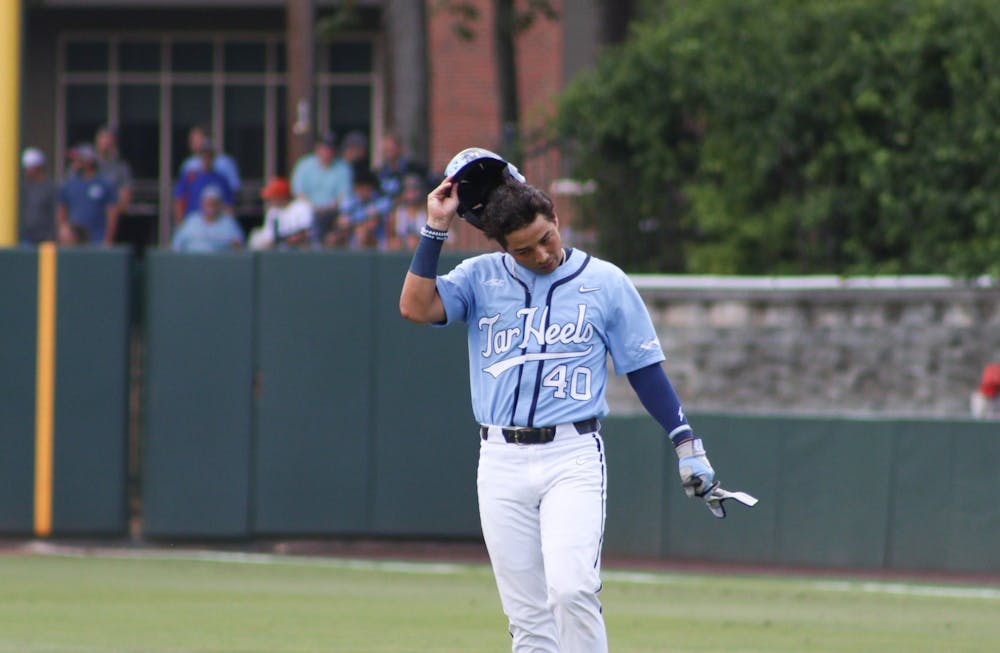 Redshirt junior right fielder Angel Zarate (40) removes his helmet as he walks off the field. UNC lost 3-4 against Arkansas at home in the NCAA Super Regionals on Sunday, June 12, 2022.