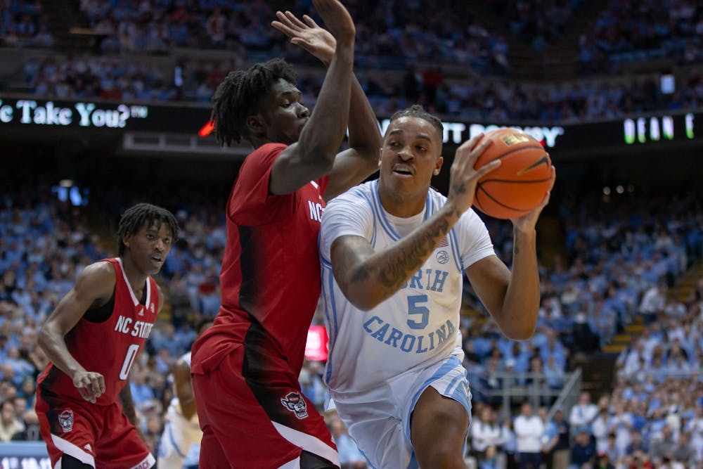 <p>UNC senior forward/center Armando Bacot (5) passes the ball in the Dean Smith Center on Jan. 21, 2023, against the N.C. State Wolfpack. UNC won 80-69.</p>