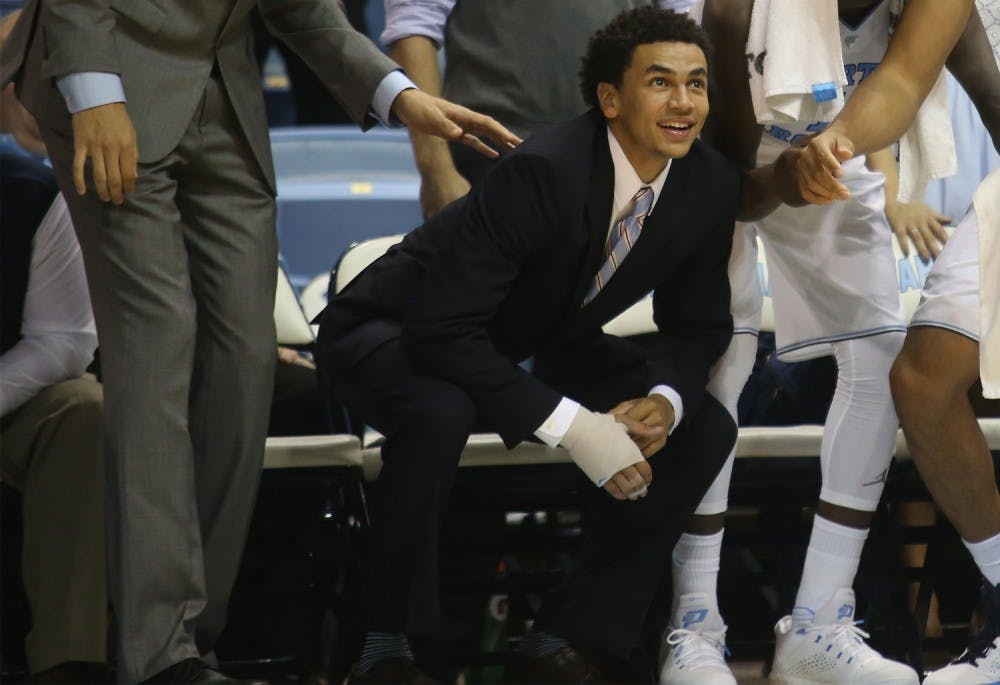 (Left to right) Justin Jackson, Marcus Paige, Theo Pinson, and Brice Johnson watch from the sidelines. Jackson and Paige were unable to play for health reasons. 