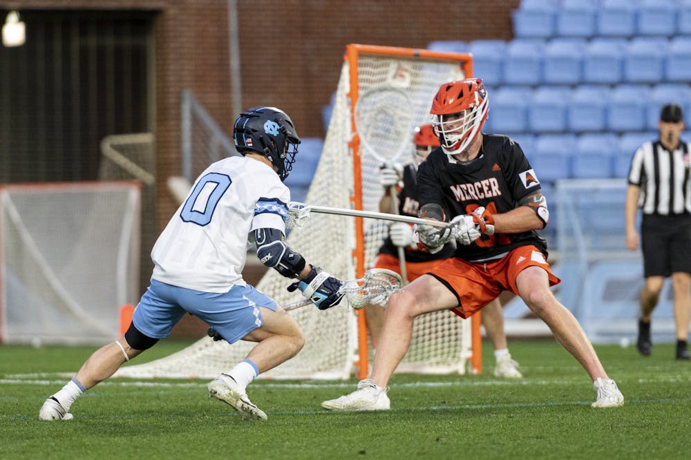 UNC senior attackman Lance Tillman (0) moves around the goal before shooting and scoring during the Men’s Lacrosse game against Mercer at Dorrance Field on Friday, Feb. 10, 2023. UNC beat Mercer 25-3.