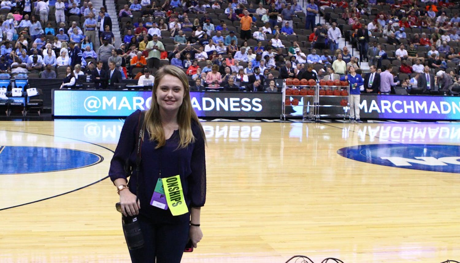 The Daily Tar Heel senior photographer Halle Sinnott stands on the court during half time of Thursday's game. 