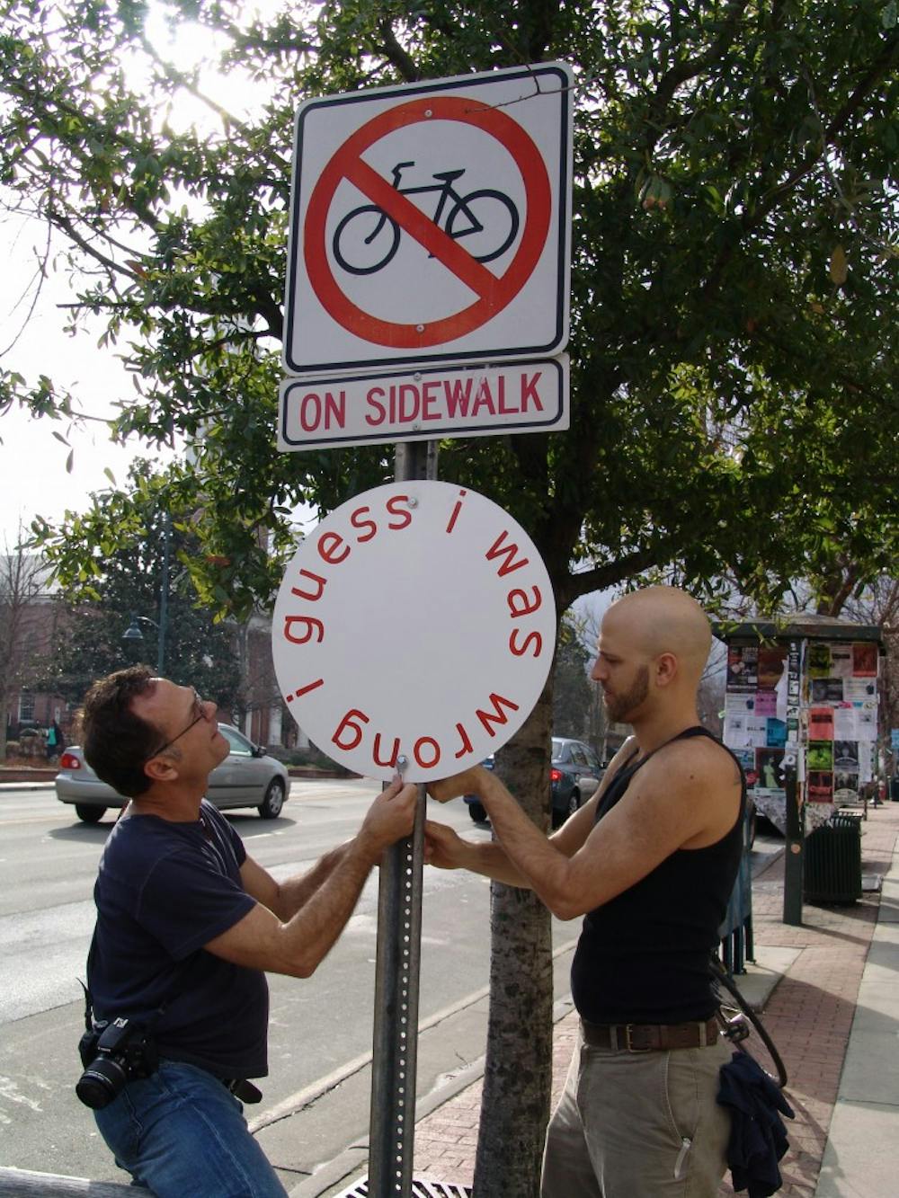 	<p>Artist Gregory Sale (left) and Ackland preparator Andrew Nagy install one of Sale’s signs on Franklin Street. Photo by Emily Bowles. </p>