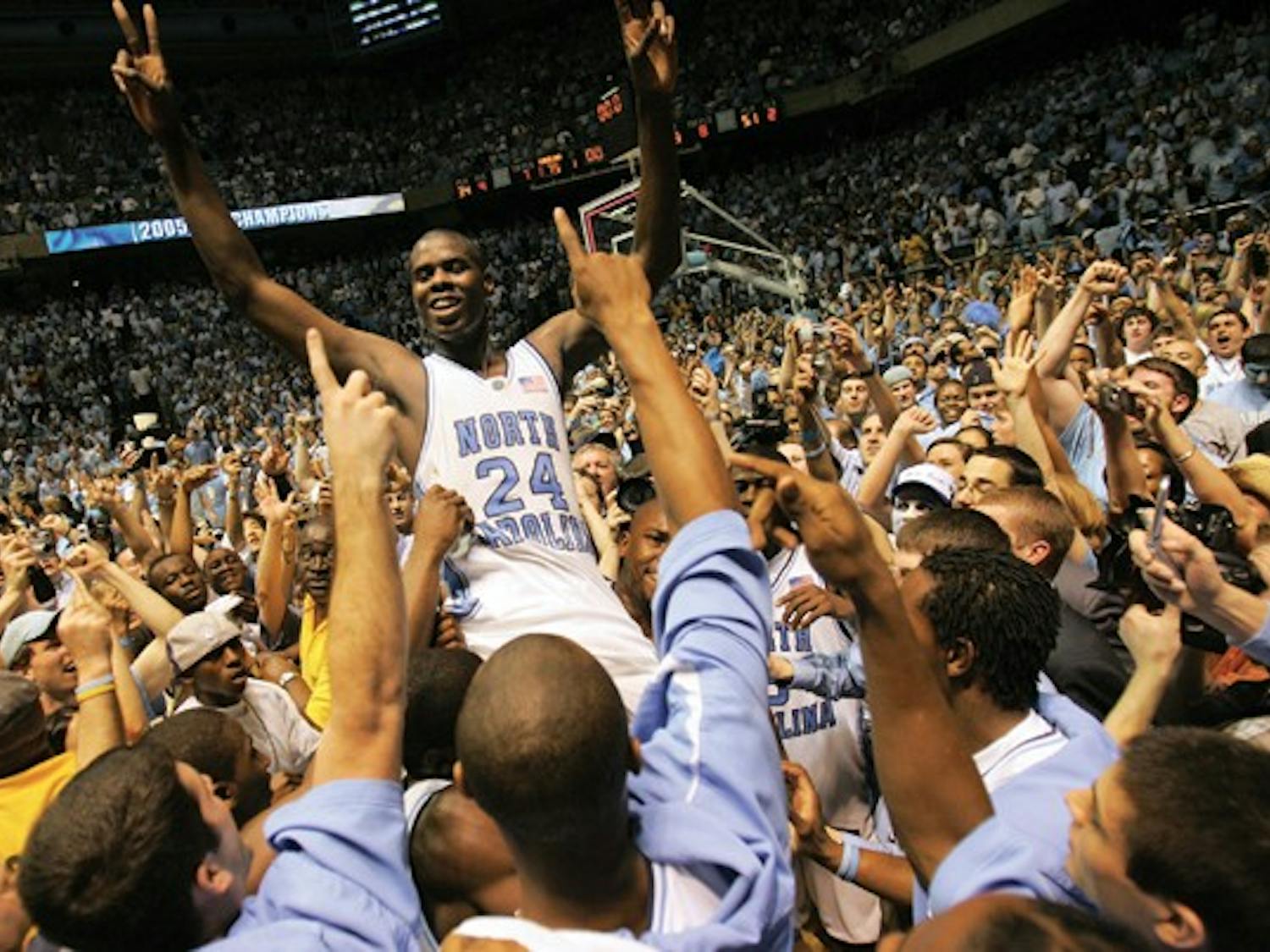 North Carolina's Marvin Williams (24) rides a wave of jubilant, powder blue-clad fans after UNC's 75-73 win against Duke on Sunday, March 6, 2005. William's put-back and free throw gave the Tar Heels the winning margin with 17 seconds left.