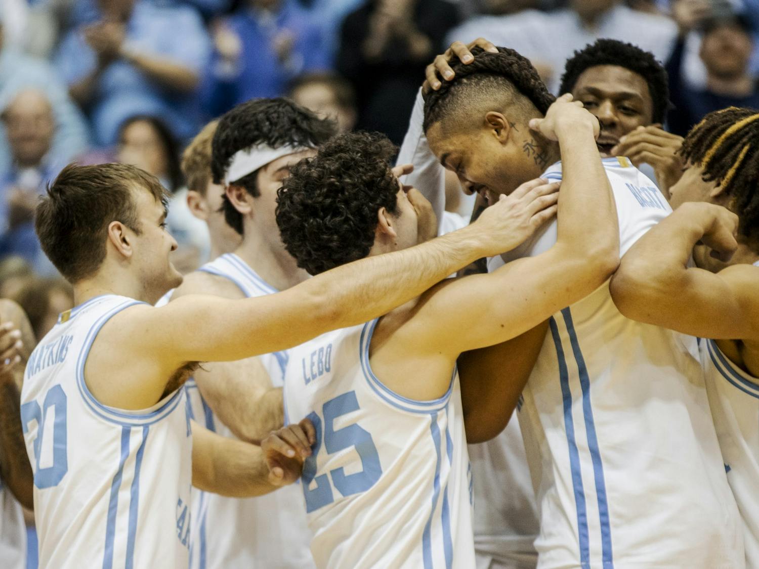 UNC senior forward Armando Bacot (5) is embraced by his teammates after setting a record for the most career double-doubles during a basketball game against N.C. State on Saturday, Jan. 21, 2023, in the Dean E. Smith Center. UNC won 80-69.