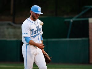UNC junior pitcher Connor Bovair (27) plays with the baseball while waiting for a review during the baseball game against Duke at Boshamer Stadium on Friday, March 24, 2023. UNC fell to Duke 8-5.