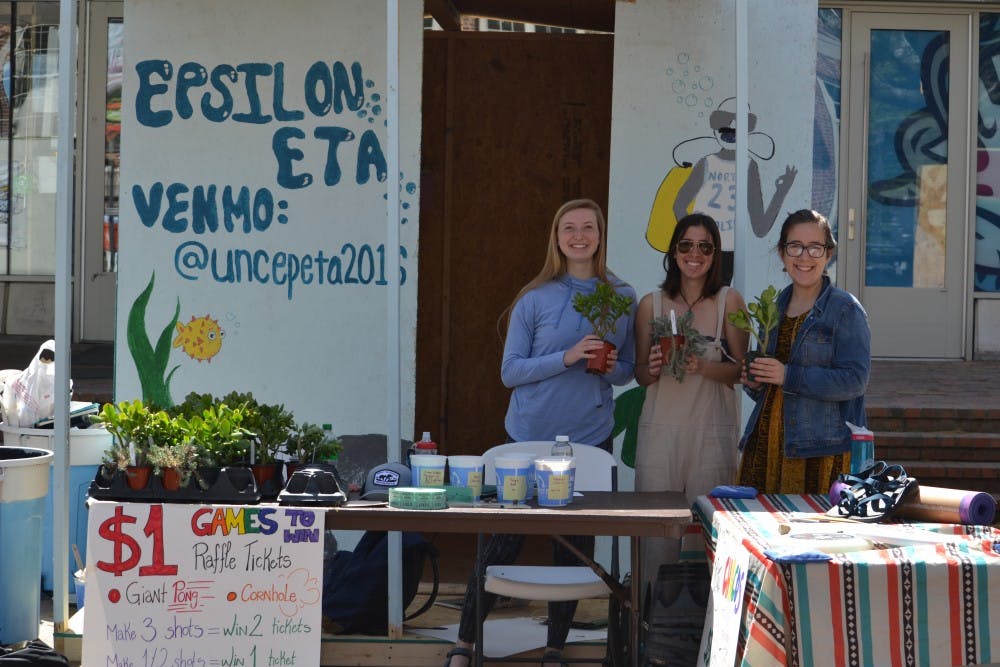 UNC students (from left to right) Emma Karlok, Allie Omens, and Elinor Solnick host the Epsilon ETA shack. Epsilon ETA raffled off various outdoor gear and sold succulents to raise money for Habitat for Humanity.&nbsp;