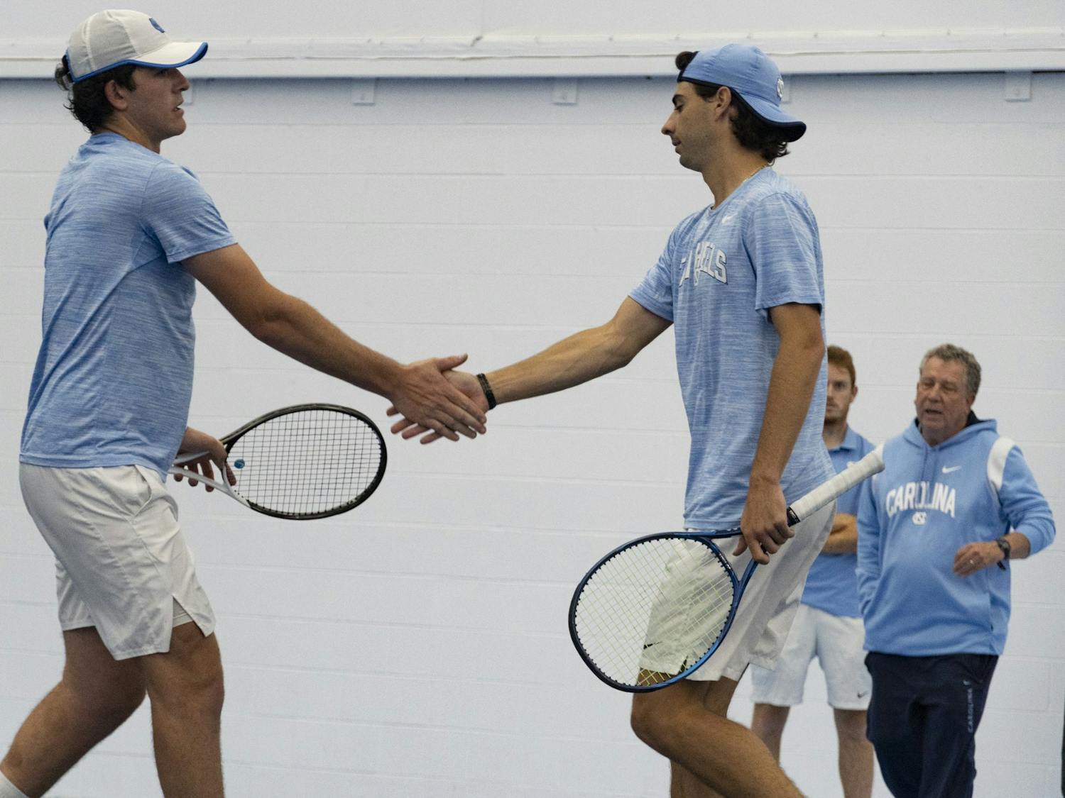 UNC tennis players, junior Logan Zapp and first-year Benjamin Kittay, hit hands during the home matchup against Duke at Cone-Kenfield Tennis Center on Saturday, April 8, 2023. UNC fell to Duke 5-2.