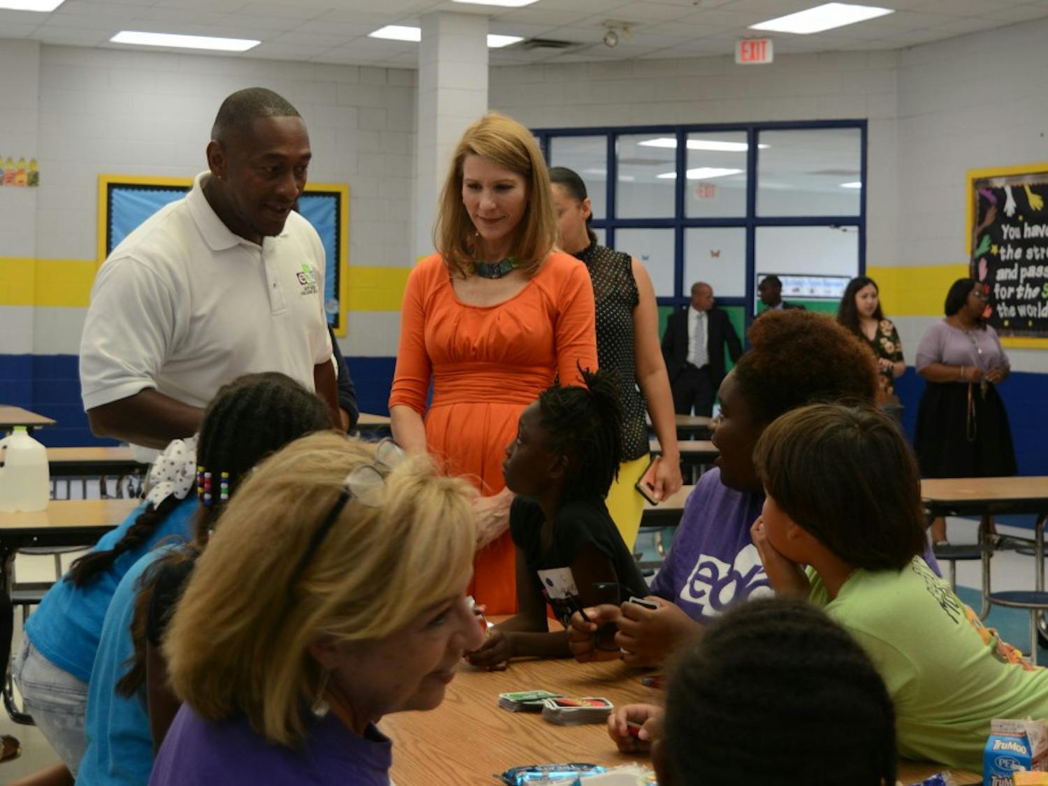 First Lady Kristin Cooper (right) and ECDI President David Reese (left) speak to students during lunchtime of the summer program at Eastway Elementary. 