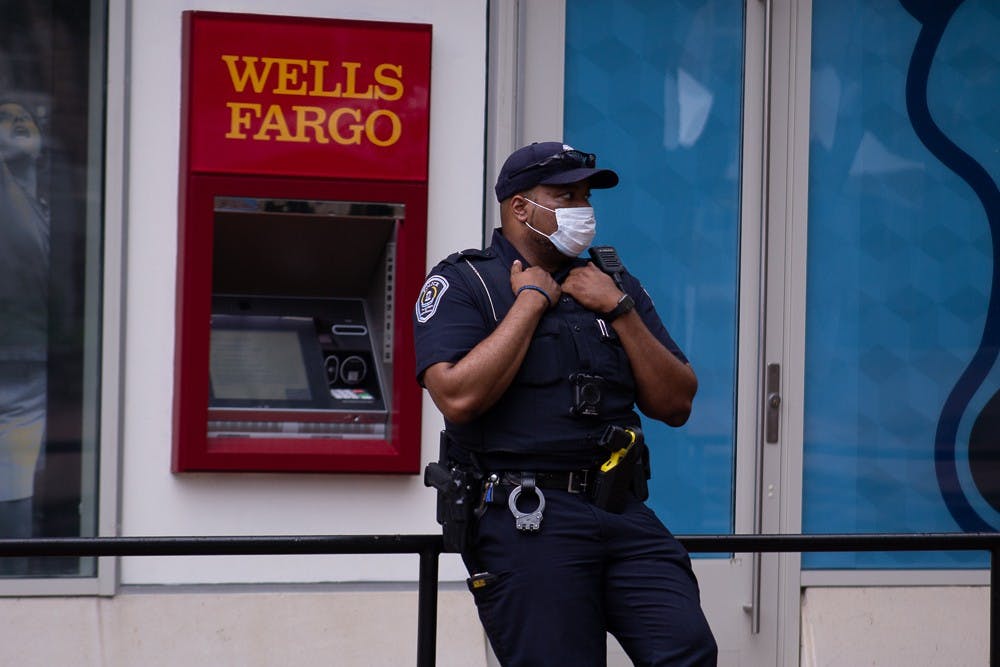 A UNC Chapel Hill police officer stands outside the Student Stores building on Thursday, Aug. 6, 2020.