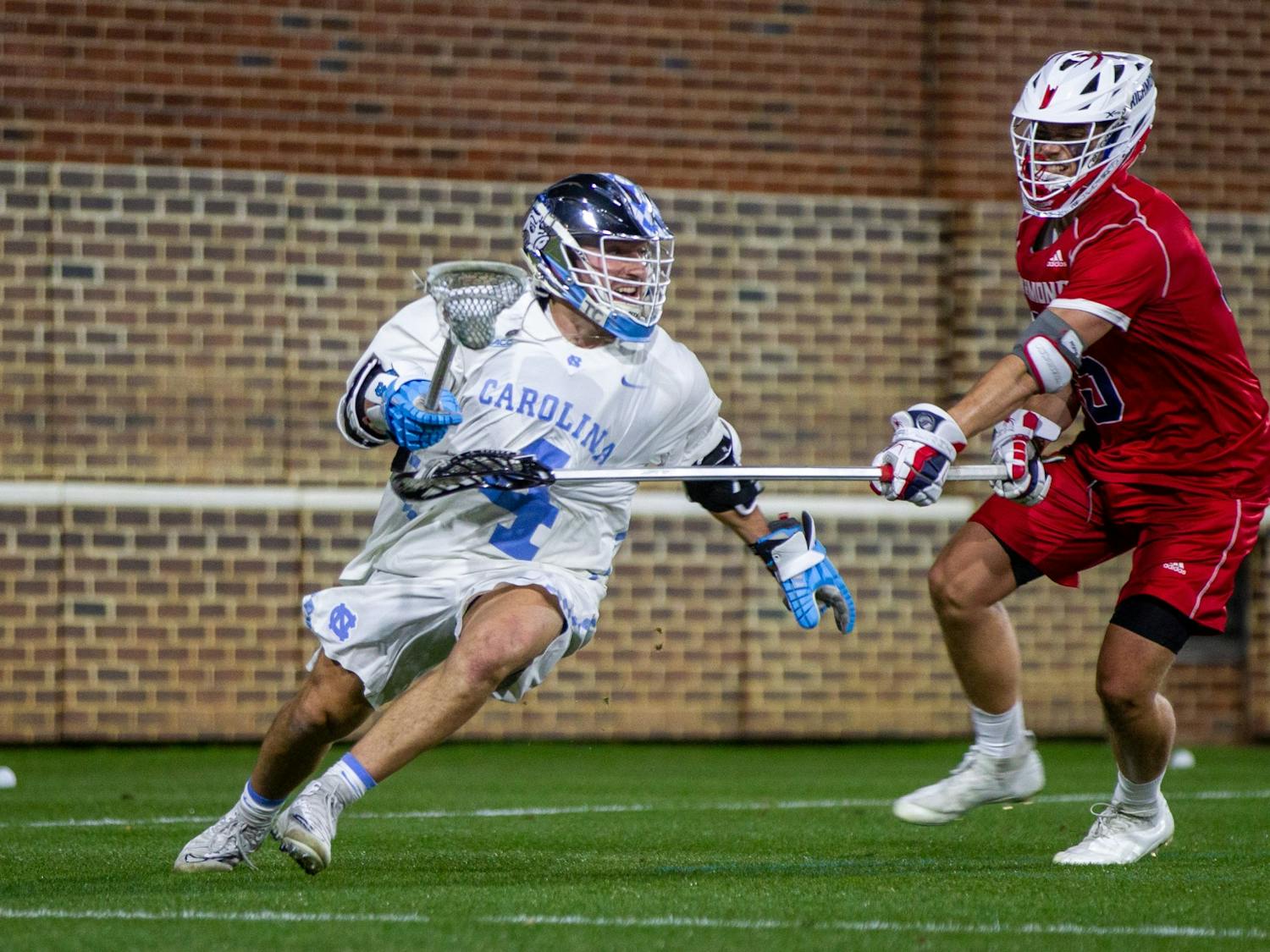 Graduate student attackman Chris Gray (4) is defended at the men's lacrosse game against Richmond on Feb. 11, 2022 at Dorrance Field in Chapel Hill. UNC won 13-9.