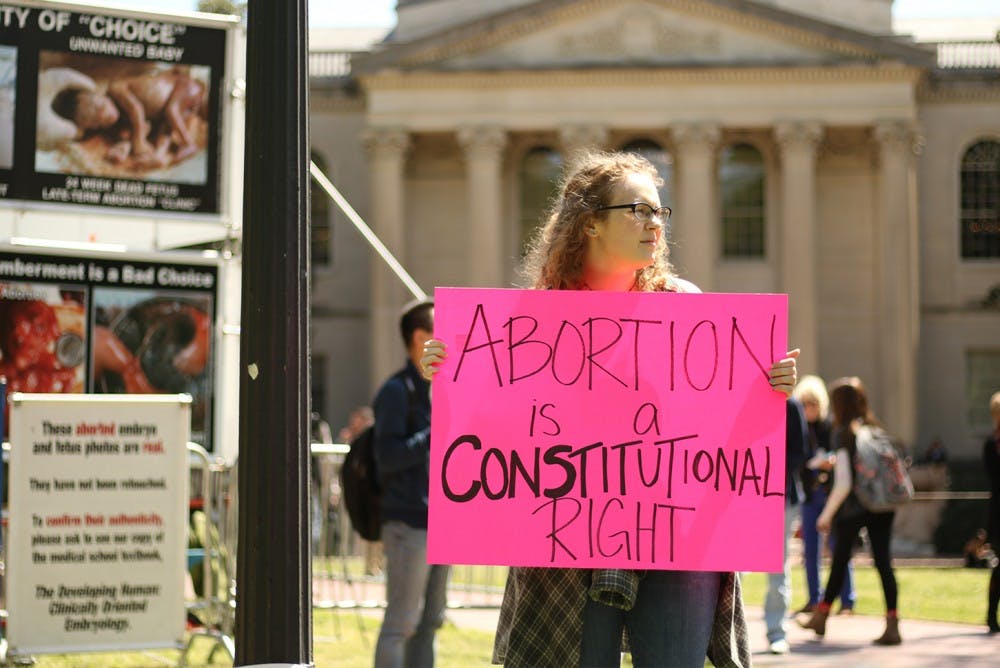 Senior geology major Michelle Gavel participates in the counter-protest against anti-abortion group the Genocide Awareness Project. Gavel was invited to protest the display by friends with shared views, and expresses disappointment in GAP's return to campus.