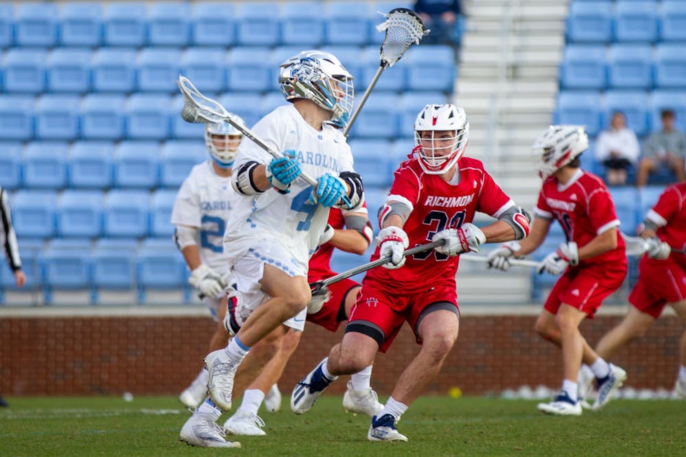 Graduate student attackman Chris Gray (4) runs with the ball at the lacrosse game agianst Richmond at Dorrance field on Feb. 11, 2022.