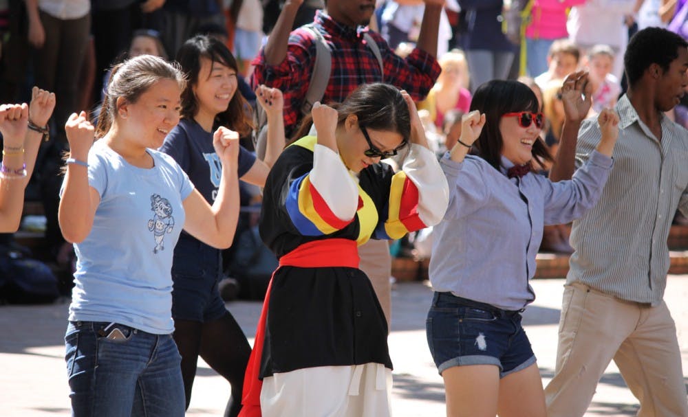 The Korean American Student Association (KASA) organized a Gangnam Style flash mob in the pit. Soobin Seong, a junior Global Studies major (left), Seung Hui Choi, a junior economics major (middle), and Inhye You, a senior chemistry major (right), began the "horse riding dance," and hundreds of students joined later.