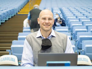 Former professional basketball player and UNC basketball star Eric Montross sits at the broadcasters table before the UNC men's basketball game against NC State on Jan. 29, 2022.
