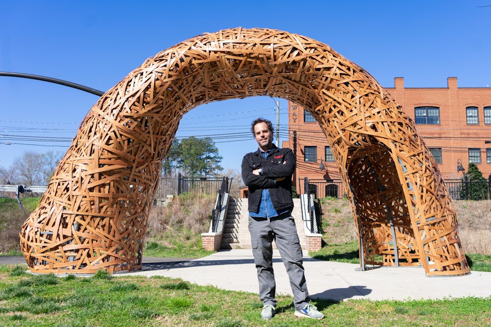 Installation Artist Jonathan Brilliant poses with his newest installation in River Park in Downtown Hillsborough, NC on Mar. 25. More of his work can be seen at jonathanbrilliant.com.