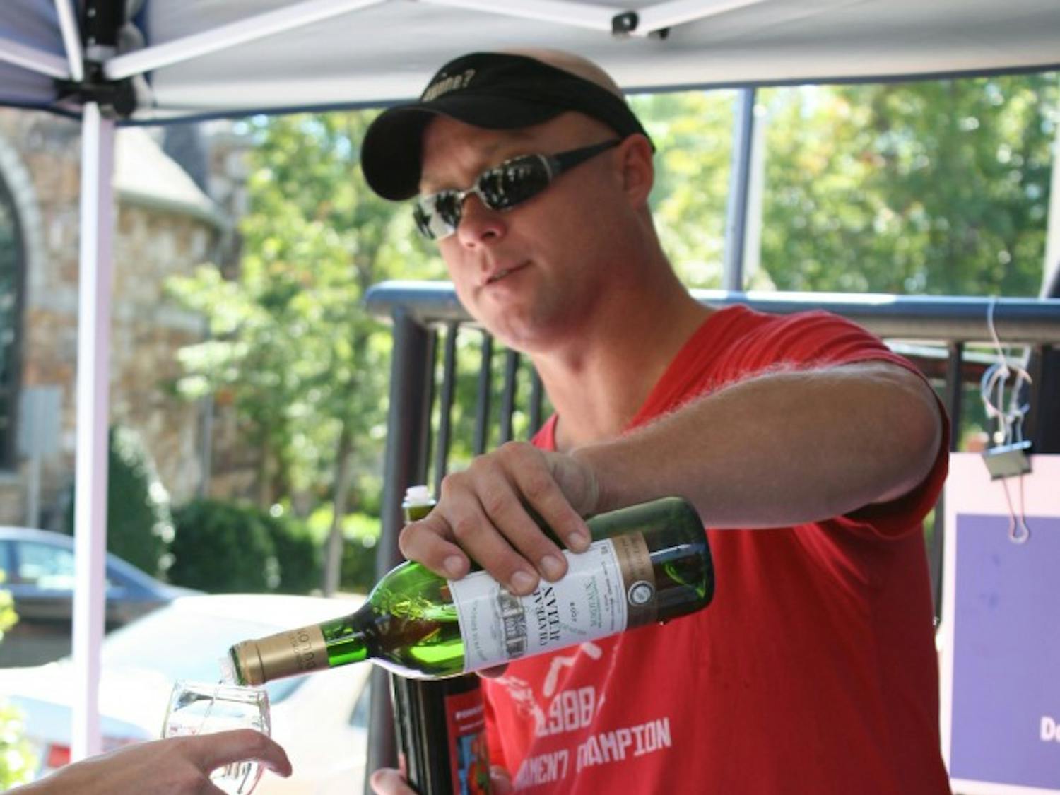Dan Benthall pours a glass of wine at the Weaver Street Market 7th Annual Fall Wine Sale and Show at Southern Village on Saturday. 