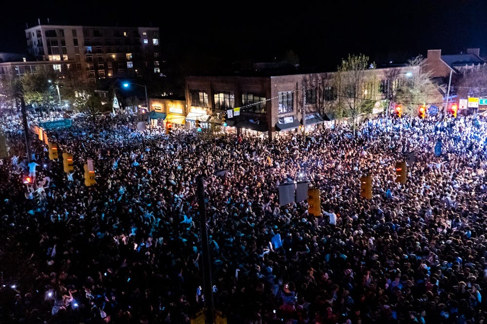 <p>Fans rush Franklin Street after a historic North Carolina men's basketball win over Duke in the Final Four game on April 2, 2022. UNC won 81-77.</p>