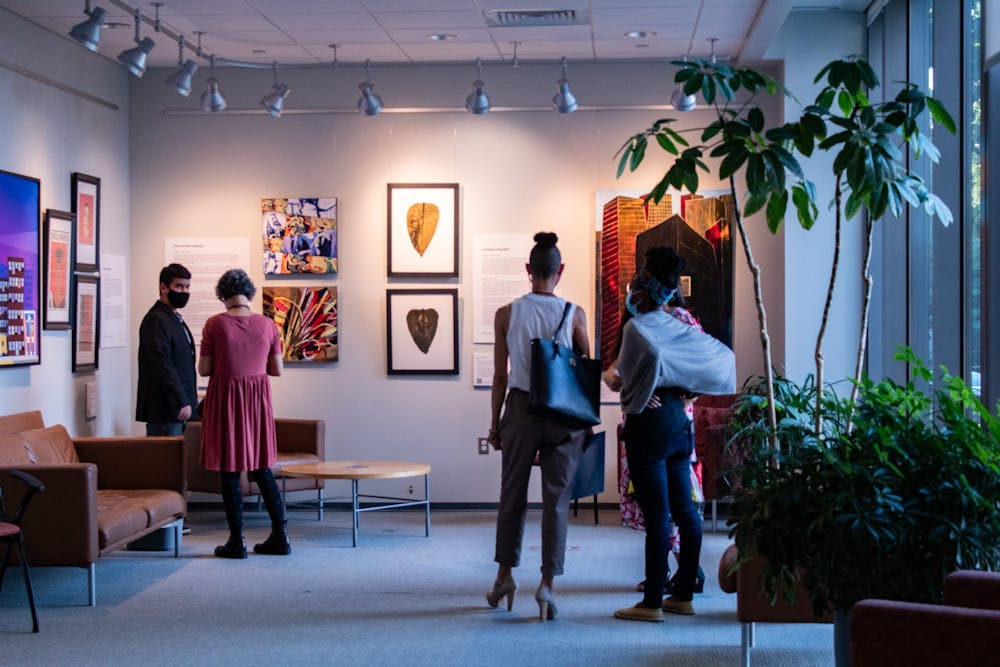 Artists and viewers admire the art of the thirteen LatinX artists on display for the Being and Belonging exhibit at the Fedex Global Center on Oct. 5.