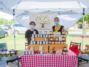 Andrea Davis, owner of Valley Brook Farms, stands with co-worker Matthew Pittman behind their booth at the Carrboro Farmers Market on Wednesday June 9, 2021. Valley Brook Farms is a local farm that makes a variety of jams, jellies, and pickled goods.