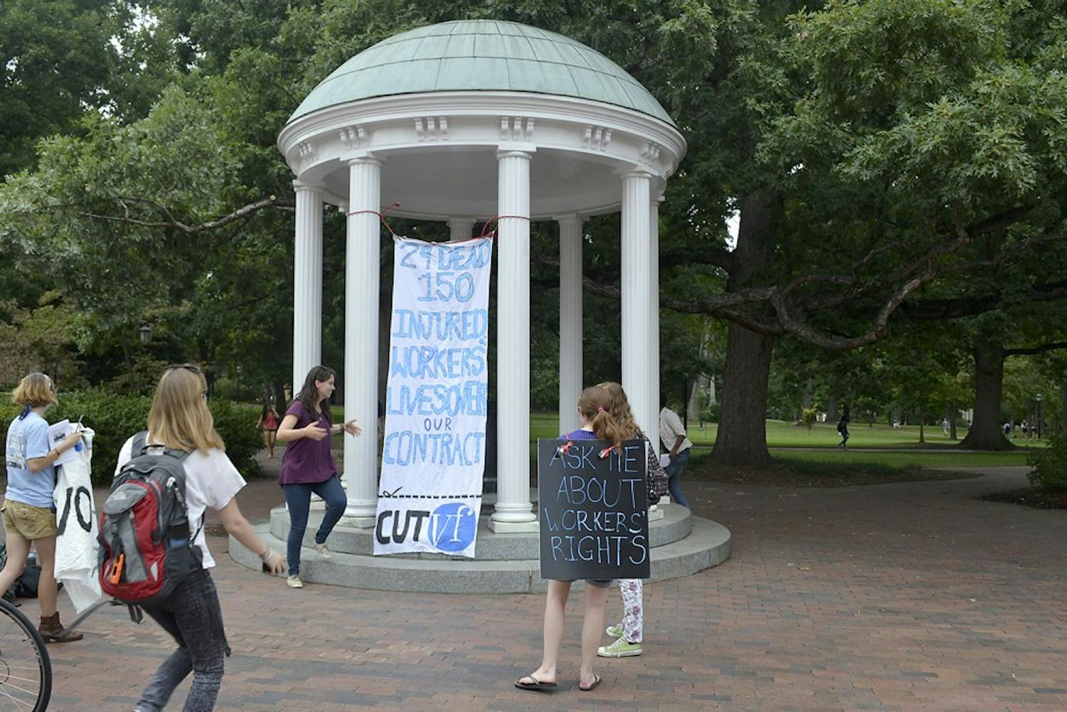 Members of SAW with their banner at the Old Well on Wednesday afternoon.  The banner was hung in hopes to gain the attention of Chancellor Folt and UNC students.