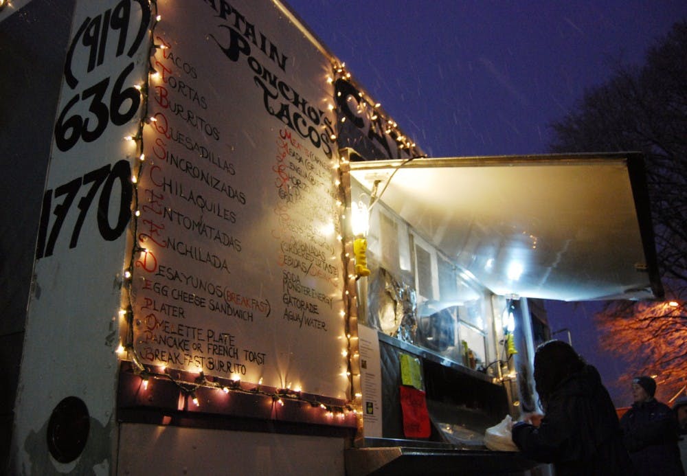 During the snow storm, community members purchase food at Captain Poncho’s Tacos as a part of the Carrboro Food Truck Showcase on Saturday evening. Food trucks are difficult to operate in Chapel Hill because of regulations, but the trucks are common in Carrboro.