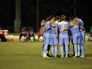 The men's soccer team huddle during a game against George Washington on Sep. 19 at WakeMed Soccer Park in Cary.
