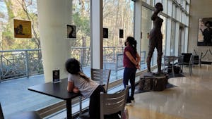 Lucila Perez and her younger sister look at the pages from "An American Story" on Wednesday, Feb. 22 in the Sonia Hayes Stone Center for Black Culture and History.&nbsp;